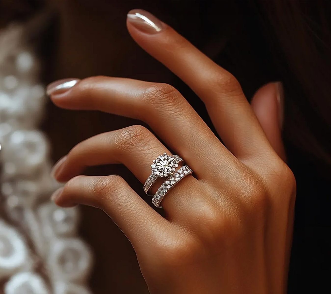 Hand wearing a diamond engagement ring with matching diamond band